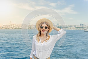 Beautiful woman traveler stands in front of Bosphorus.