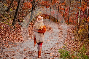 Beautiful woman traveler is walking in the autumn forest