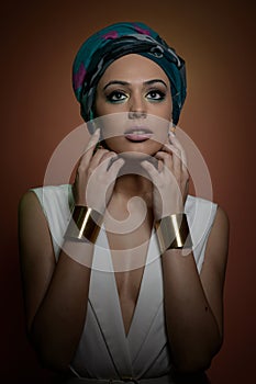 Beautiful woman with turban. Young attractive female with turban and golden accessories. Beauty fashionable woman