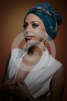 Beautiful woman with turban. Young attractive female with turban and golden accessories. Beauty fashionable woman