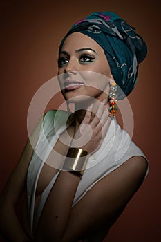 Beautiful woman with turban. Young attractive female with turban and golden accessories. Beauty fashionable woman