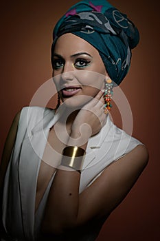 Beautiful woman with turban. Young attractive female with turban and golden accessories. Beauty fashionable woman