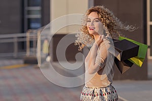 Beautiful woman turning around and smiling with shopping bags. happy girl with their purchases.