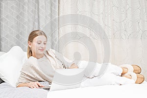 Beautiful woman is typing on her computer on bed