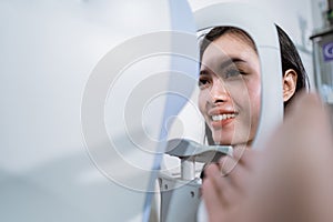 A beautiful woman is undergoing an examination using an eye examiner