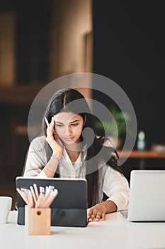 A beautiful woman is using a computer tablet.