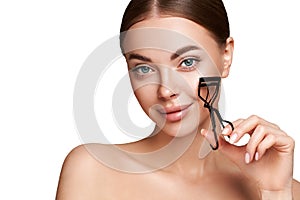 Beautiful woman using eyelash curler