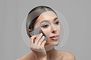 Beautiful woman using facial oil blotting paper. Beauty concept. Cosmetology, cosmetics