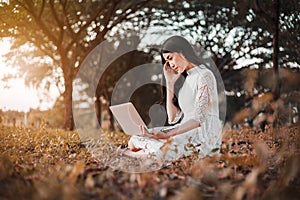 Beautiful woman using laptop in the park