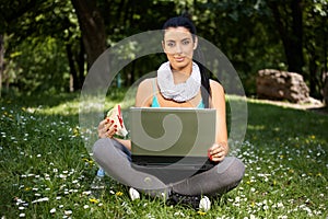 Beautiful woman using laptop in park