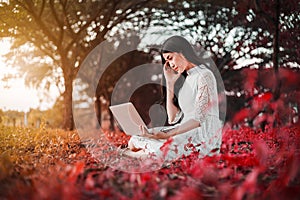 Beautiful woman using laptop in the park