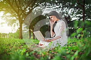 Beautiful woman using laptop in the park