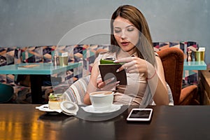Beautiful woman using a mobile phone in cafe. Reading e-book