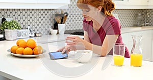Beautiful woman using mobile phone while having breakfast 4k