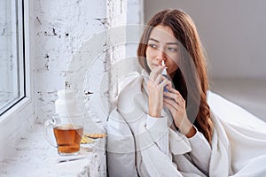 Beautiful woman using nasal spray. Close up of female feeling sick nose using sinus medication for blocked nose