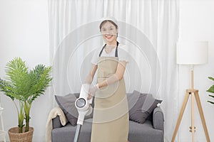 Beautiful woman vacuuming the floor of her living room