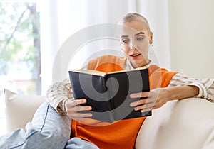 Beautiful woman with very short hair   reading book at home