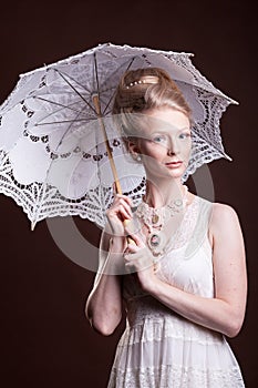 Beautiful woman in vintage dress holding a lace umbrella