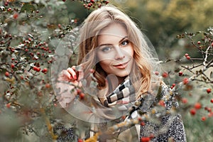 Beautiful woman in vintage knitted scarf posing near