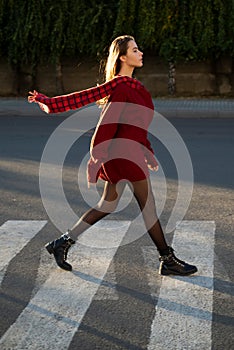 Beautiful woman walking on crosswalk in fashionable summer spring clothes outdoors. Female stylish model walking city