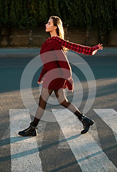 Beautiful woman walking on crosswalk in fashionable summer spring clothes outdoors. Female stylish model walking city