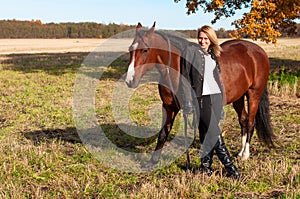 Beautiful woman walking with horse