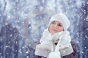 Beautiful woman walking outdoors under snowfall