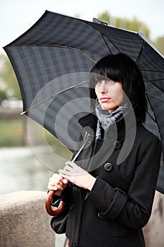 Beautiful woman walking on street with umbrella photo