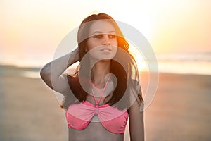 Beautiful woman walking in swimsuit walking at the beach on sunset time