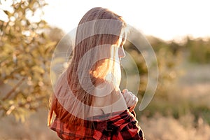 Beautiful woman in the warm rays of the setting sun