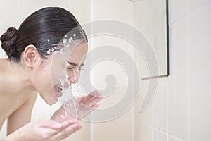 A beautiful woman is washing her face