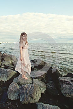 Beautiful woman wearing boho dress on ocean coast, romantic beauty portrait