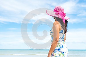 Beautiful woman wearing hat beach and sunglasses stand on hands over sandy beach