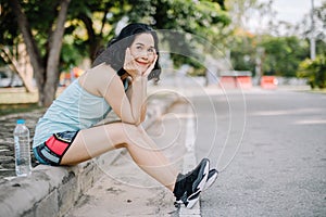 A beautiful woman wearing a jogging suit in the park early in the morning along with a clean drinking water bottle concept of