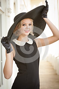 Beautiful woman wearing a large black hat and gloves