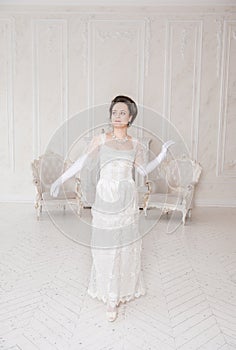 Beautiful woman wearing medieval vintage Edwardian Style dress stand in the room