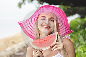 Beautiful woman wearing pink sunhat with watermelon