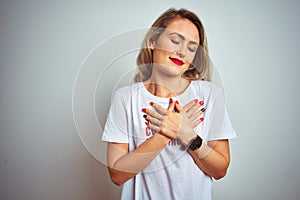 Beautiful woman wearing sacarstic comments loading t-shirt over isolated background smiling with hands on chest with closed eyes