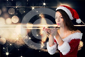 Beautiful woman wearing santa costume blowing a kiss against digitally generated christmas backgroun