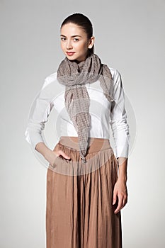 Beautiful woman wearing a scarve on grey background photo