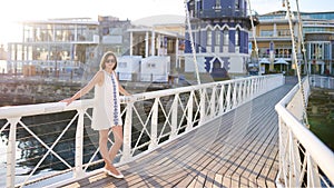 Beautiful woman wearing sunglasses looking at camera standing on bridge
