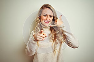 Beautiful woman wearing winter turtleneck sweater over isolated white background smiling doing talking on the telephone gesture