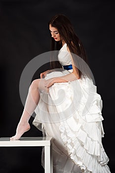 Beautiful woman in a wedding dress straightens stockings