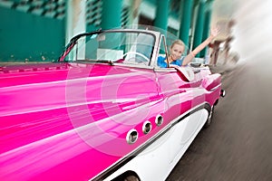 The beautiful woman at a wheel old American retro car in Old Havana, Cuba