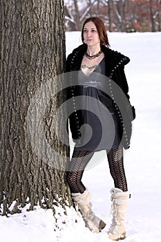 Beautiful woman in white boots standng in the snow