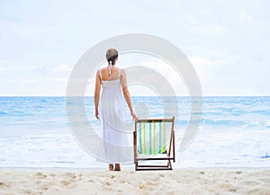 Beautiful woman in a white dress on the beach