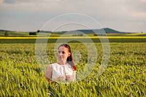 Beautiful woman in white dress on green wheat field