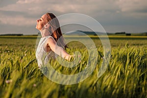 Beautiful woman in white dress on green wheat field