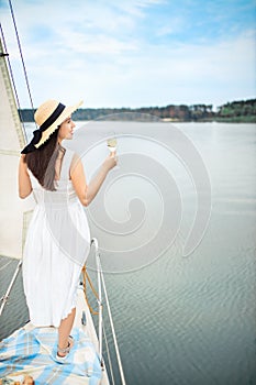 Woman with glass of champagne resting on yacht