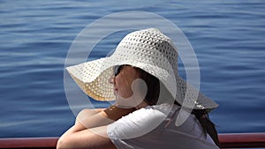 Beautiful woman with white hat have a cruise on blue sea